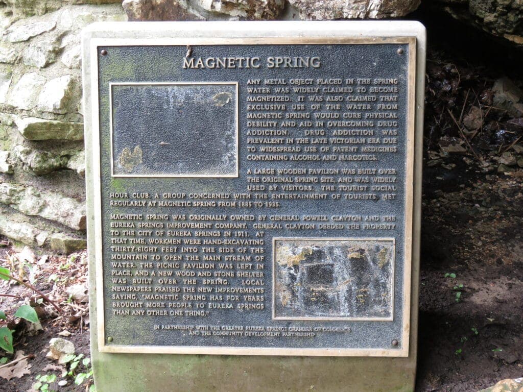 A weathered plaque detailing the history and significance of Magnetic Spring.