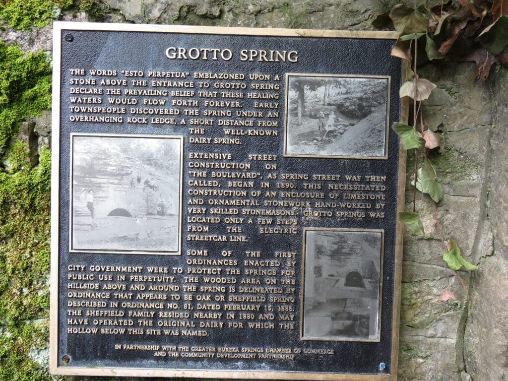 A historical plaque describing Grotto Spring, detailing its significance and the surrounding area's development.