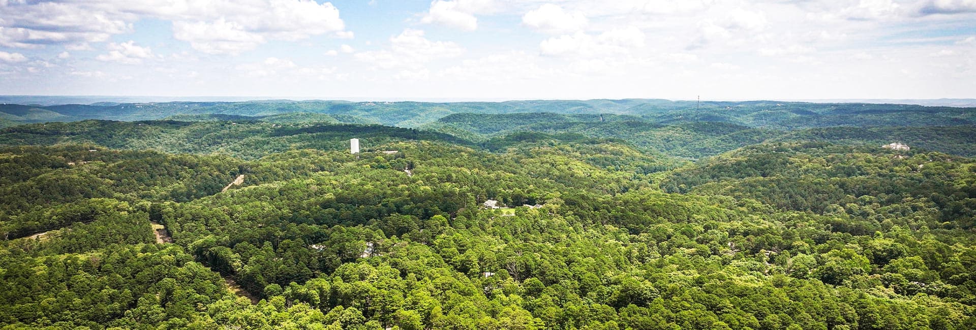 A panoramic view of lush green hills under a partly cloudy sky.